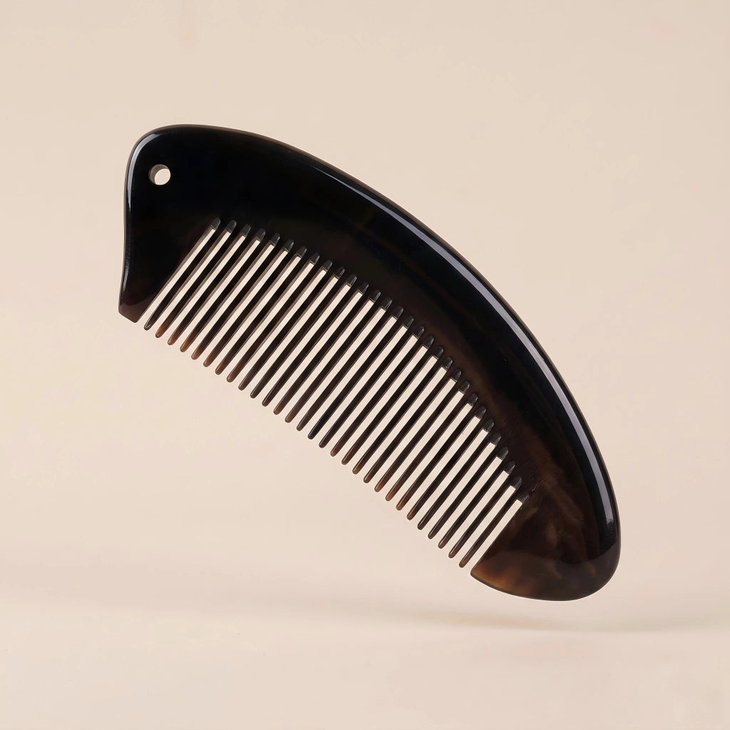 Curved black buffalo horn pocket comb floating on a beige background, daily tension and stress relief tool.