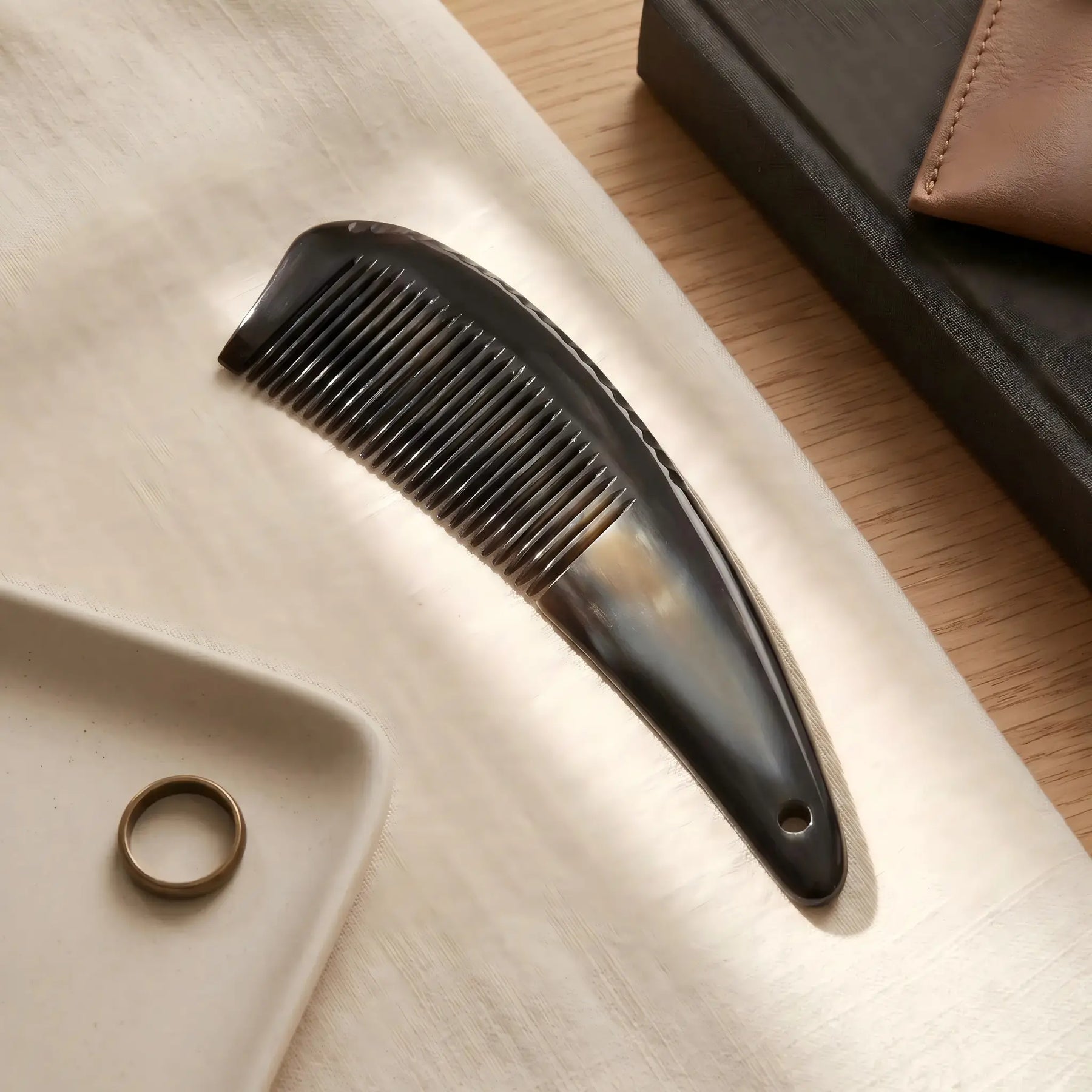 COZUY black ox horn pointed-tail comb in a styled still life showing black horn grain and pointed silhouette. detail image 6