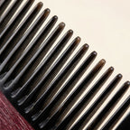 Extreme close-up of rounded horn comb teeth, precision crafted for gentle scalp massage therapy.