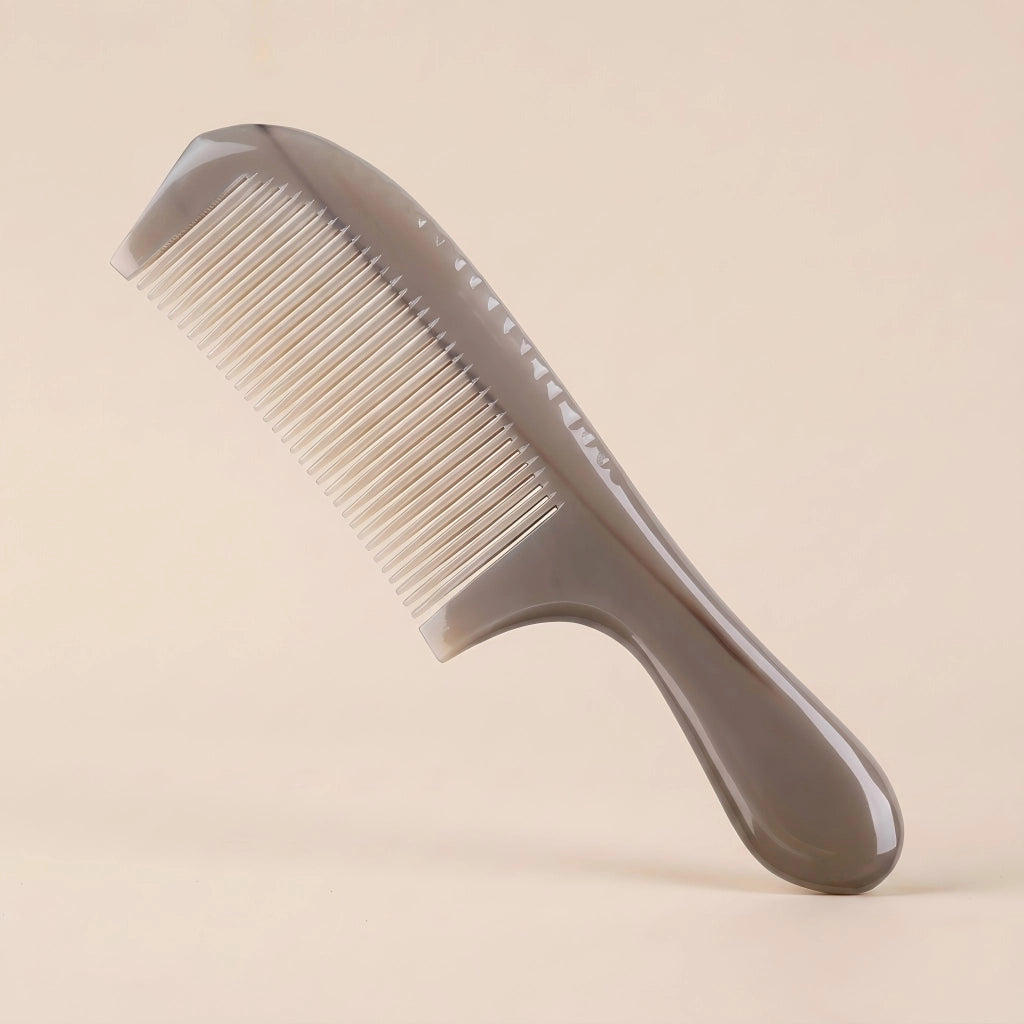 A translucent Cozuy natural horn comb standing on a beige background, designed to help reduce static and smooth flyaways.