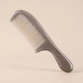 A translucent Cozuy natural horn comb standing on a beige background, designed to help reduce static and smooth flyaways.