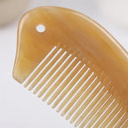A Cozuy pocket horn comb held gently in hands, serving as a mindful self care gift for women.