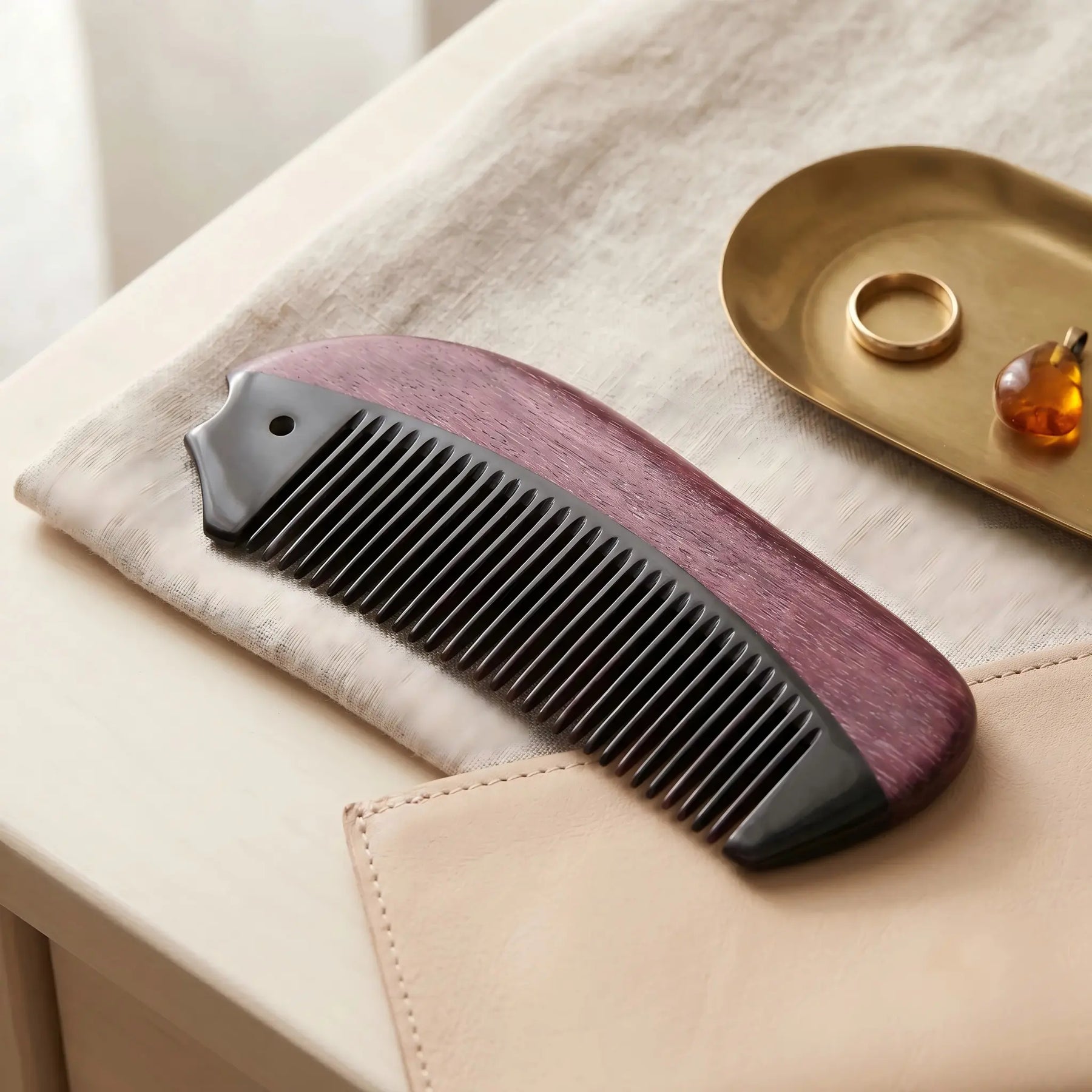 COZUY purpleheart and black ox horn pocket comb in a styled still life showing contrasting wood and natural horn grain. detail image 6
