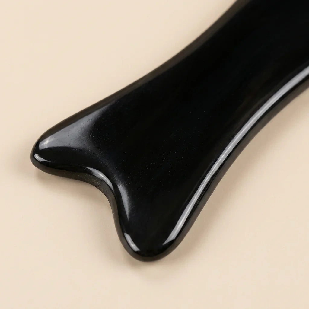 "A black Cozuy natural beauty tool held gently in hands, serving as a mindful self care gift for women.