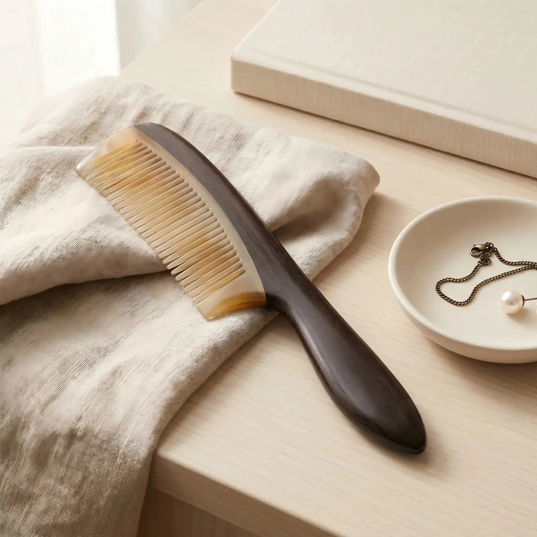 COZUY sheep horn and ebony handle comb in a styled still life showing sheep horn and ebony wood contrast. detail image 6