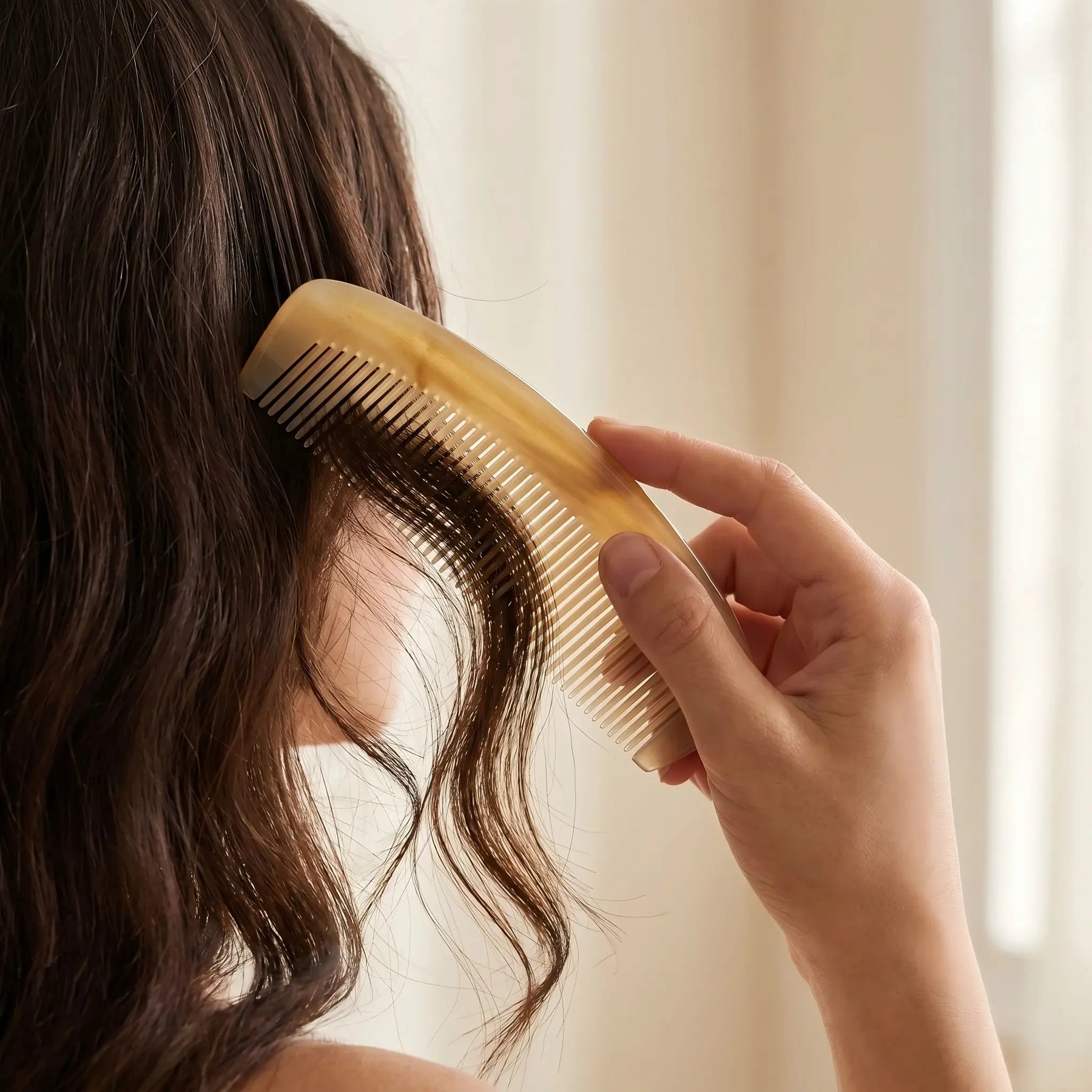 COZUY translucent sheep horn pocket comb gently combing dark hair in a daily hair-care routine. detail image 5