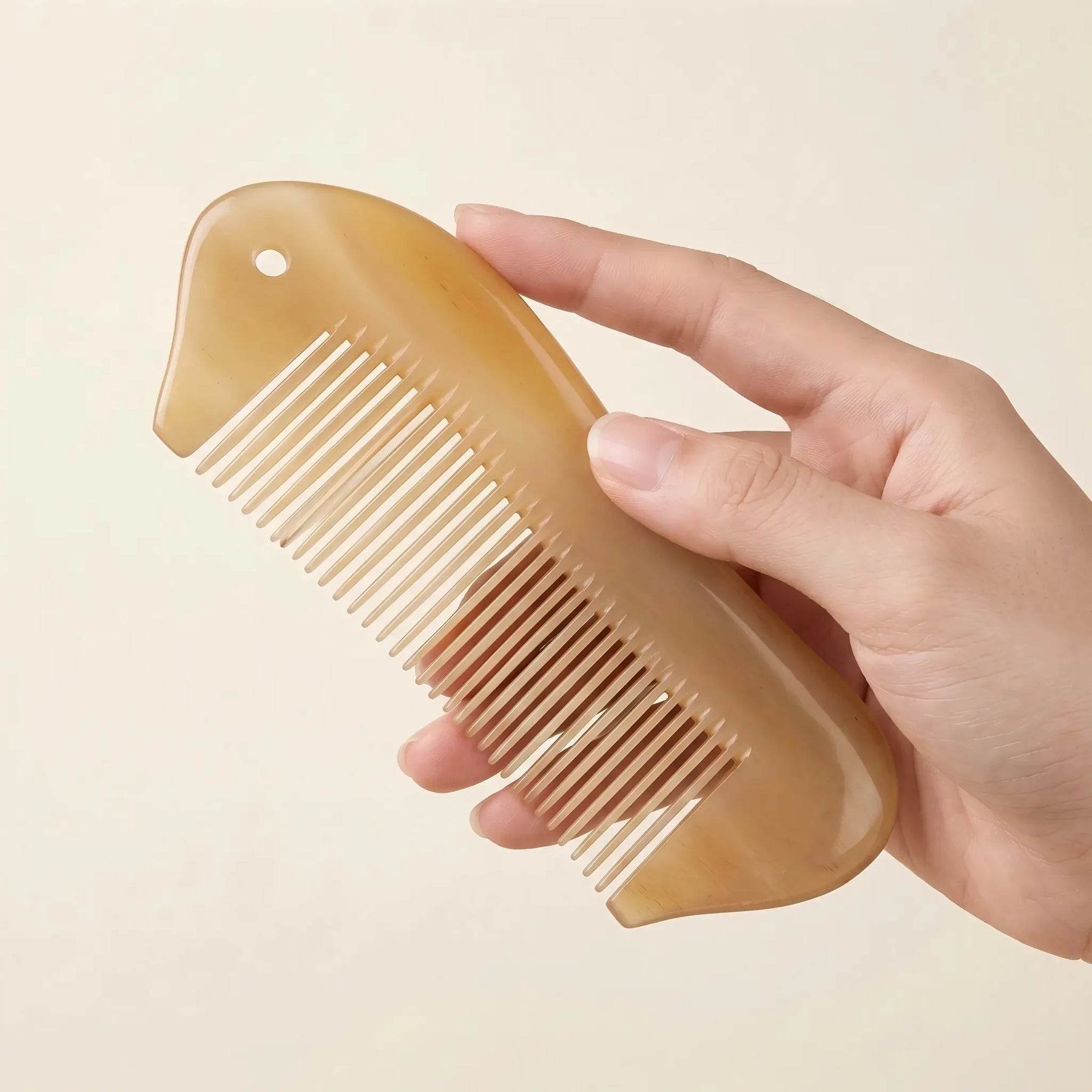 Hand holding COZUY sheep horn pocket comb to show broad curved back and compact scale. detail image 3