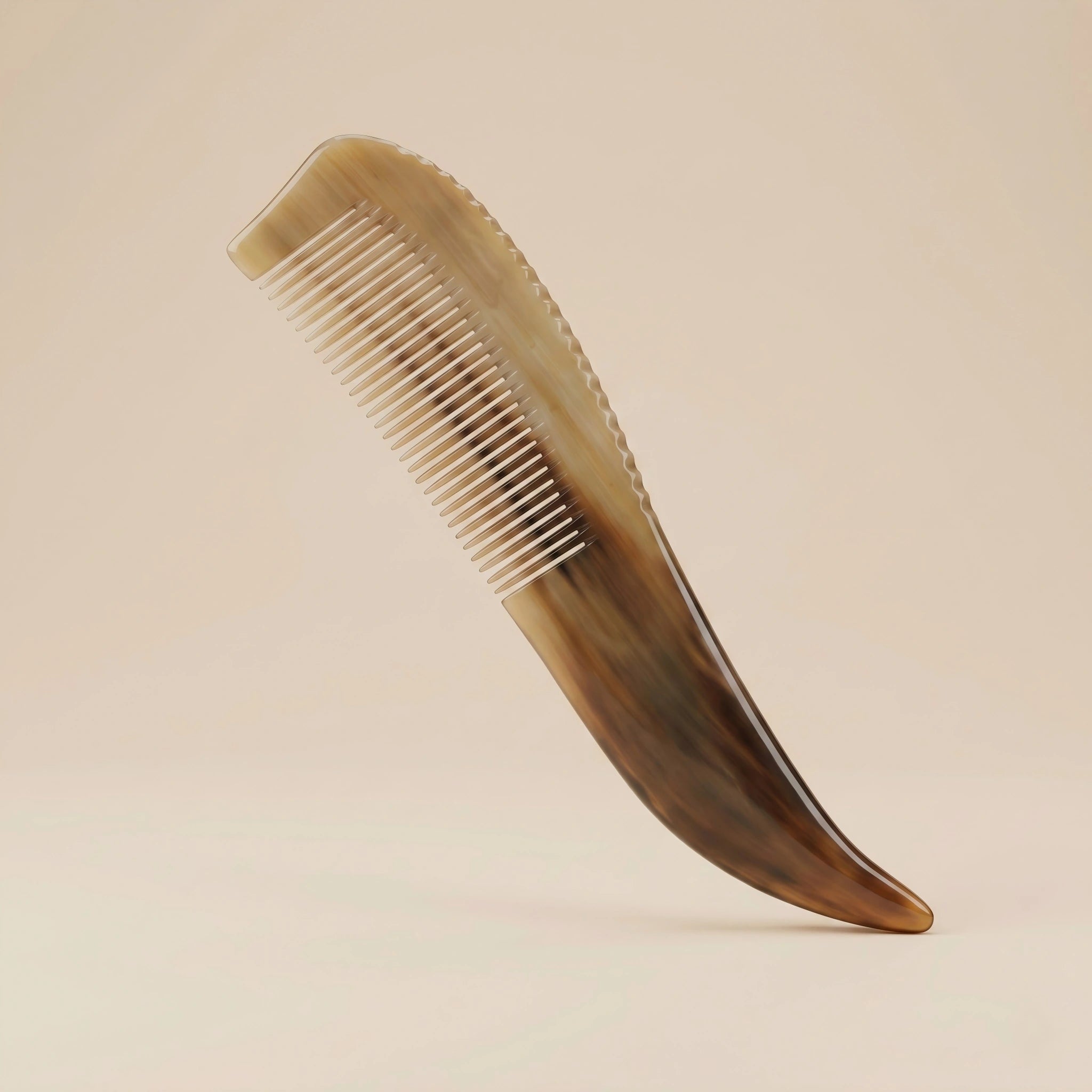 Long-handled natural horn comb with translucent brown patterns resting on a warm beige background