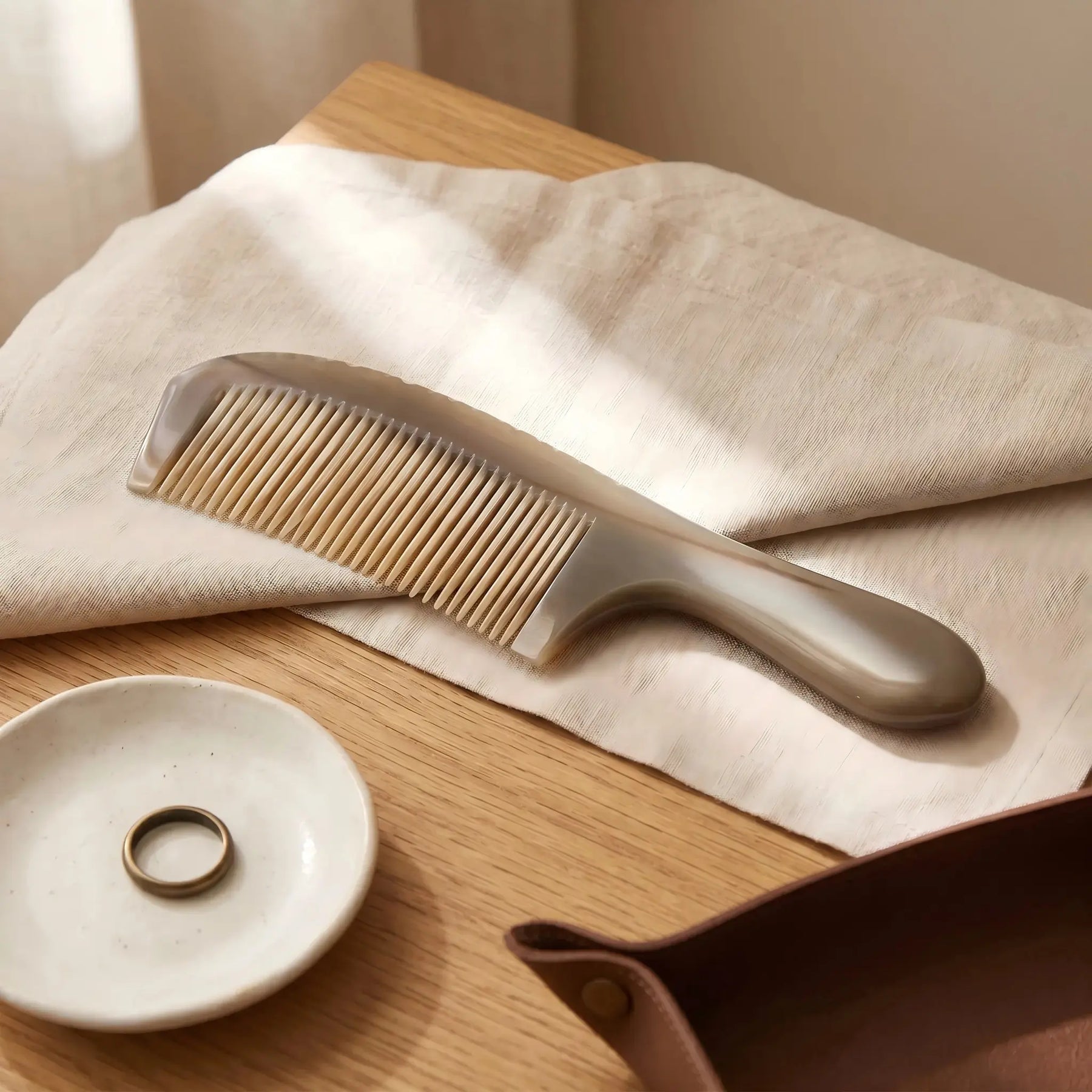 COZUY translucent yak horn handle comb in a styled still life showing translucent layers and broad rounded handle. detail image 6