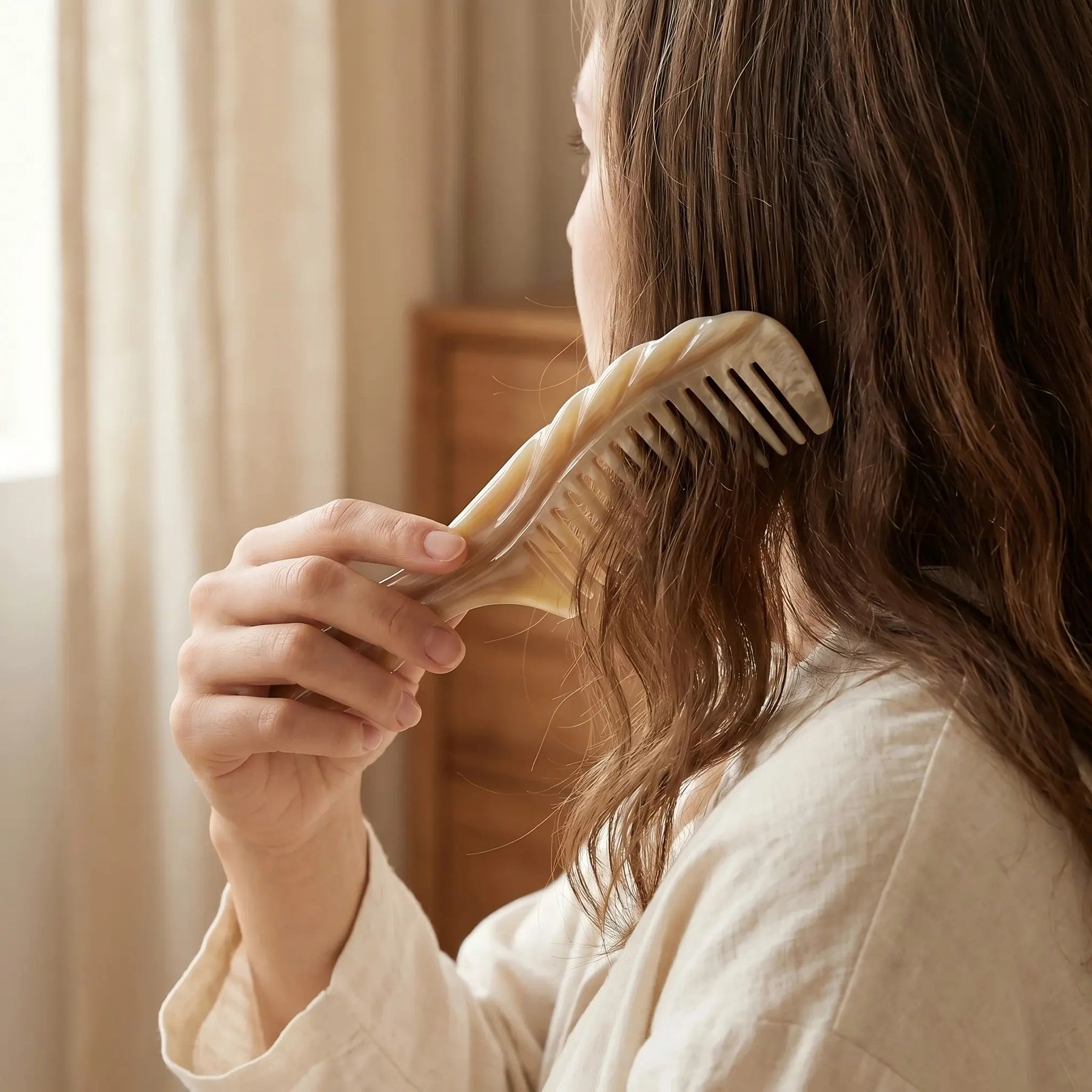 COZUY carved white yak horn comb gently combing textured hair in a daily hair-care routine. detail image 5