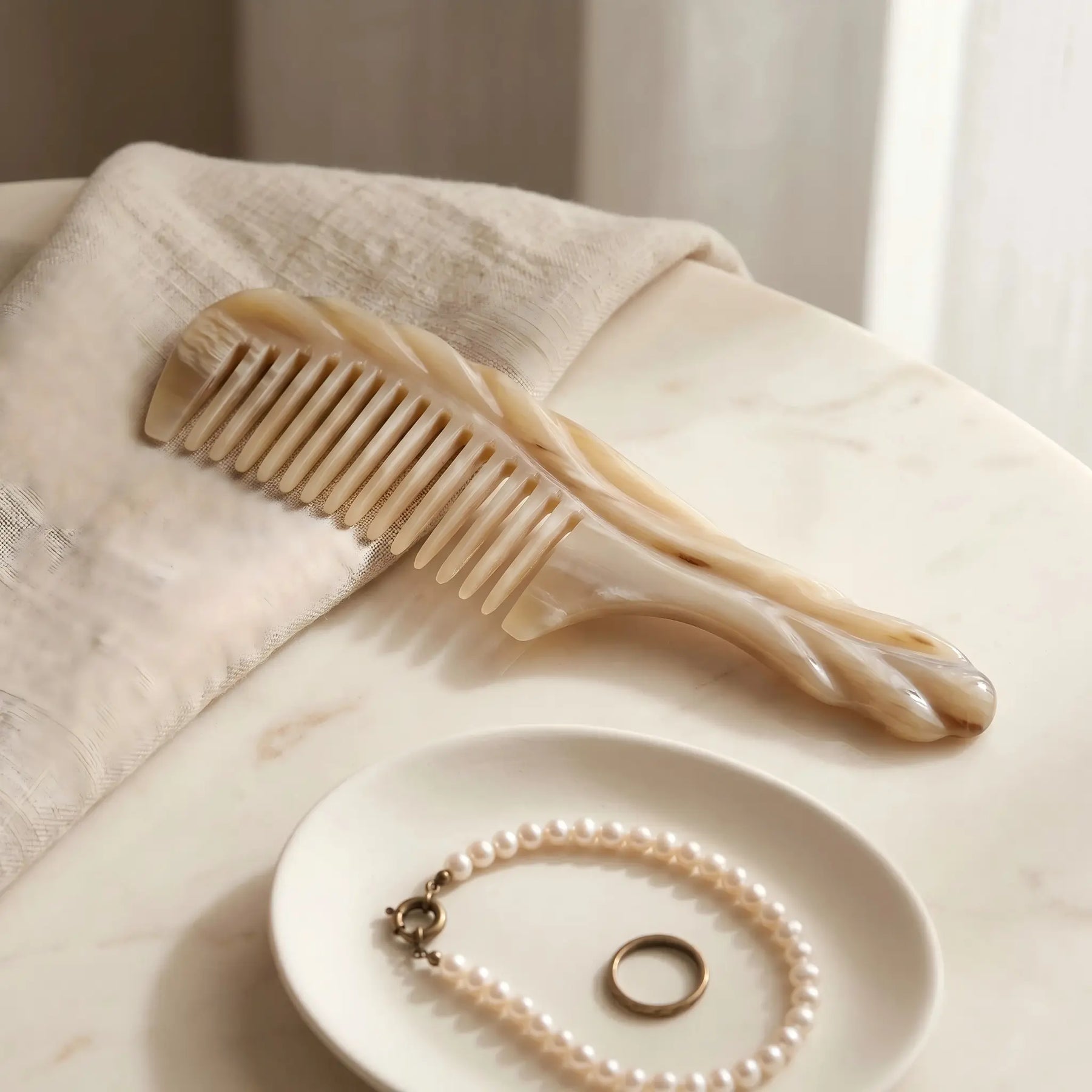 COZUY carved white yak horn comb in a styled still life showing pale marbling and hand-finished carved form. detail image 6