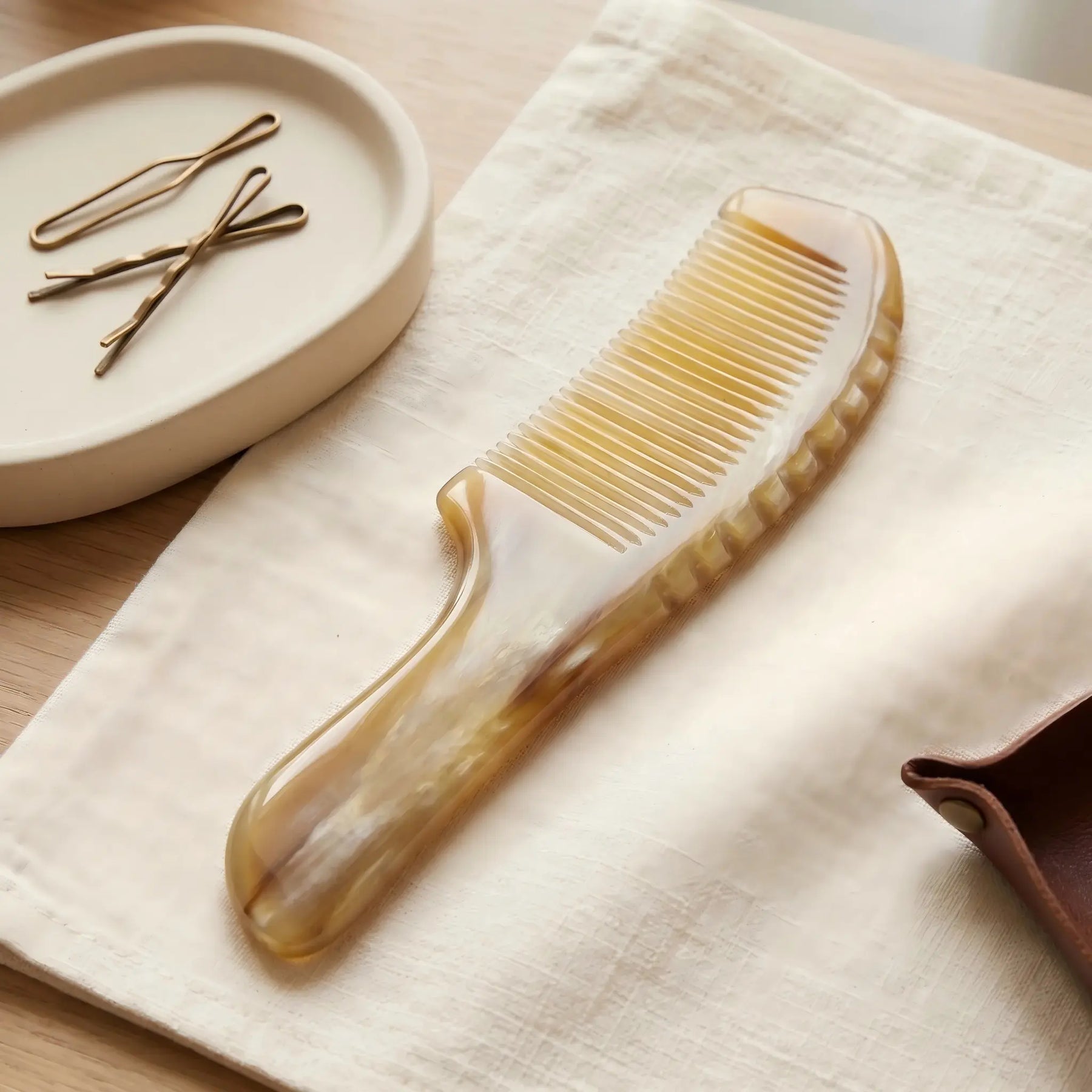 COZUY marbled white yak horn comb in a styled still life showing white marbling and hand-polished finish. detail image 6