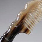 Close-up of smooth natural yak horn comb teeth and sculpted handle, precision crafted for scalp massage.