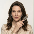 Smiling woman holding a pointed yellow horn comb next to her wavy hair, featuring premium anti-static hair care.