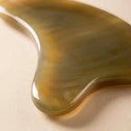 A translucent Cozuy natural beauty tool held gently in hands, serving as a mindful self care gift for women