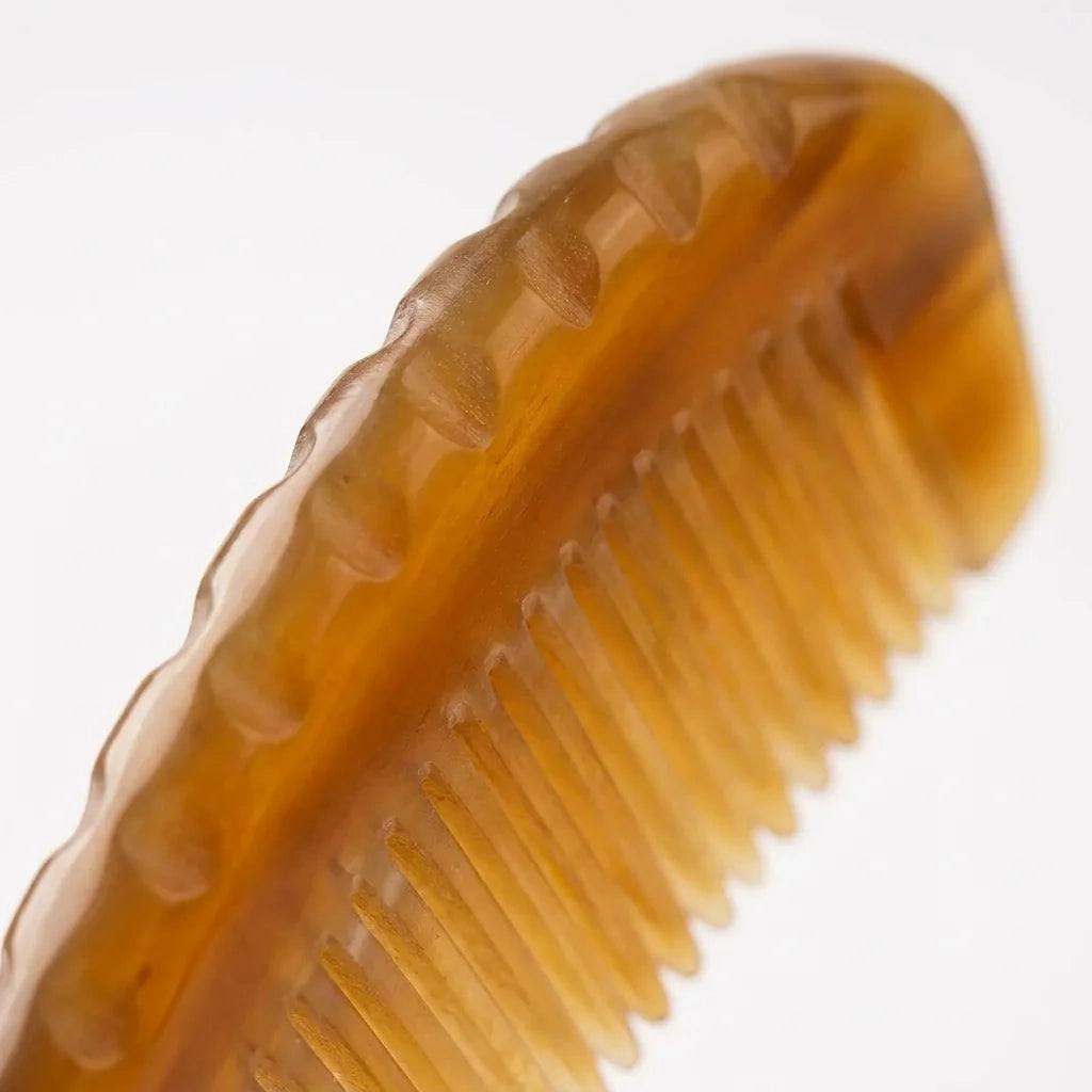 A Cozuy yak horn comb held gently in hands, serving as a mindful self care gift for women to help reduce frizz.